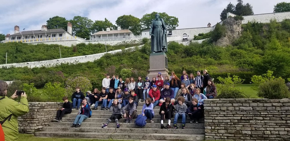 students in front of statue